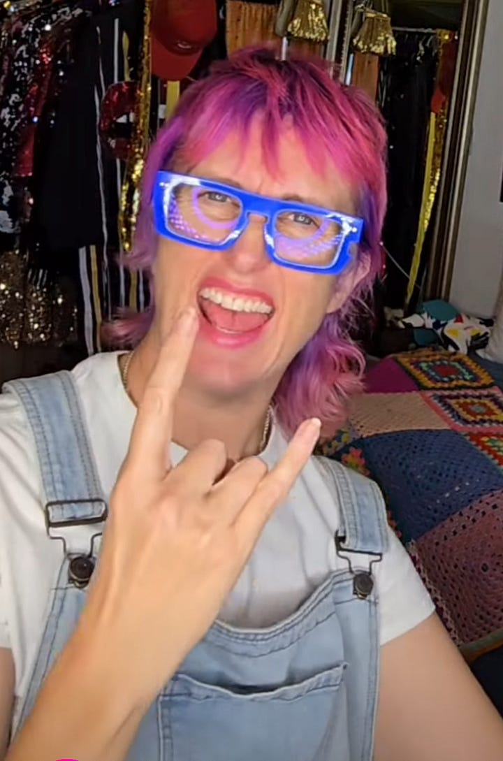 two women each with wide open mouths smiling while throwing the "goat" with their hands and fingers.