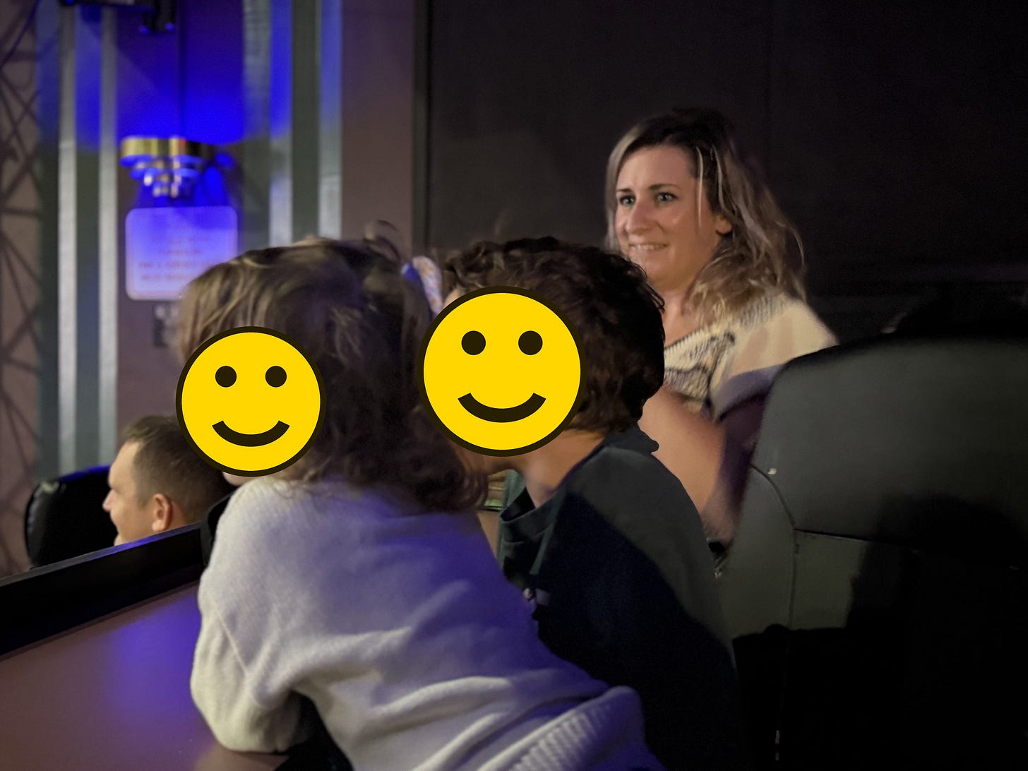 Family seated at TGR film night, children’s faces covered with smiley emojis Family seated at TGR film night, children’s faces covered with smiley emojis