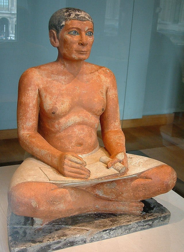 Realistically sculpted and painted statue of an ancient Egyptian scribe, middle-aged, bare-chested and seated with legs crossed, writing implements in his lap. Realistically sculpted and painted statue of an ancient Egyptian scribe, middle-aged, bare-chested and seated with legs crossed, writing implements in his lap.