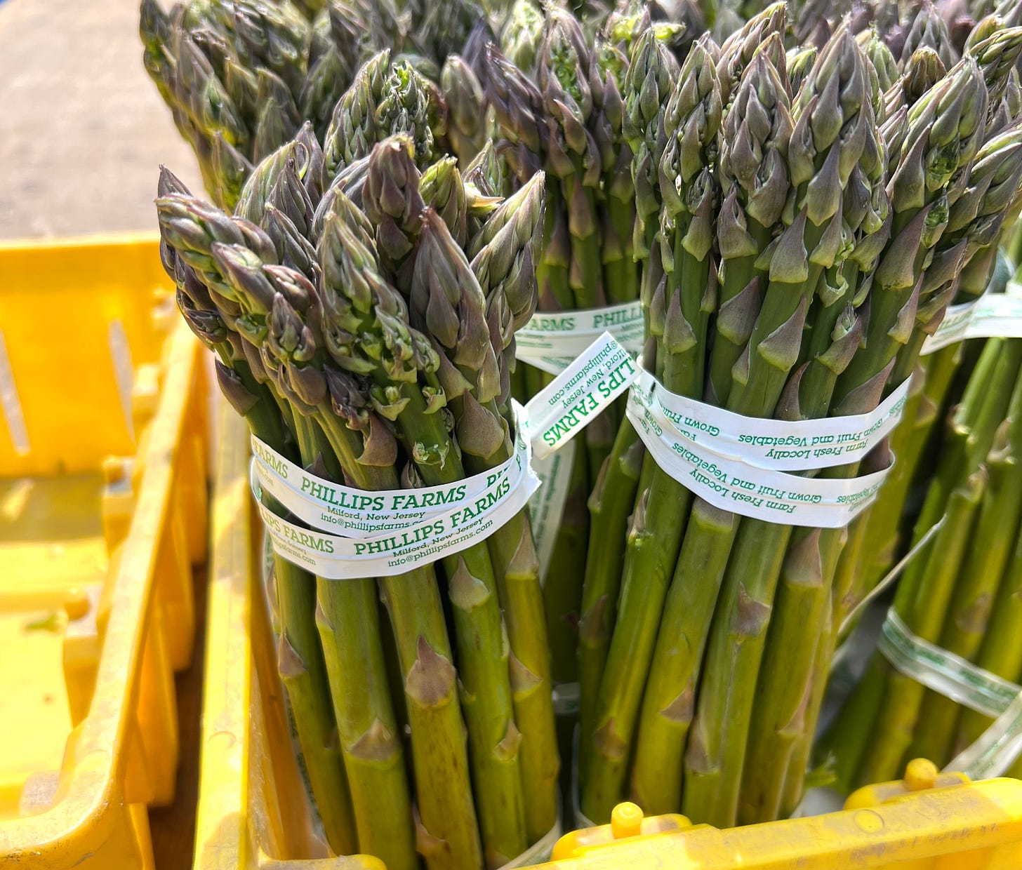 photo of asparagus at farmer's market in yellow crates.