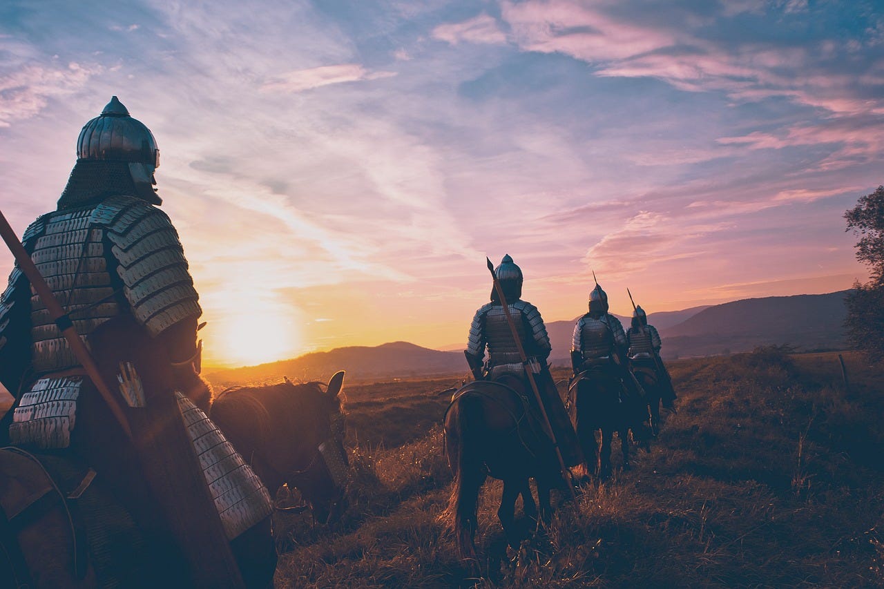 Warriors travelling in formation on horses in sunset Warriors travelling in formation on horses in sunset