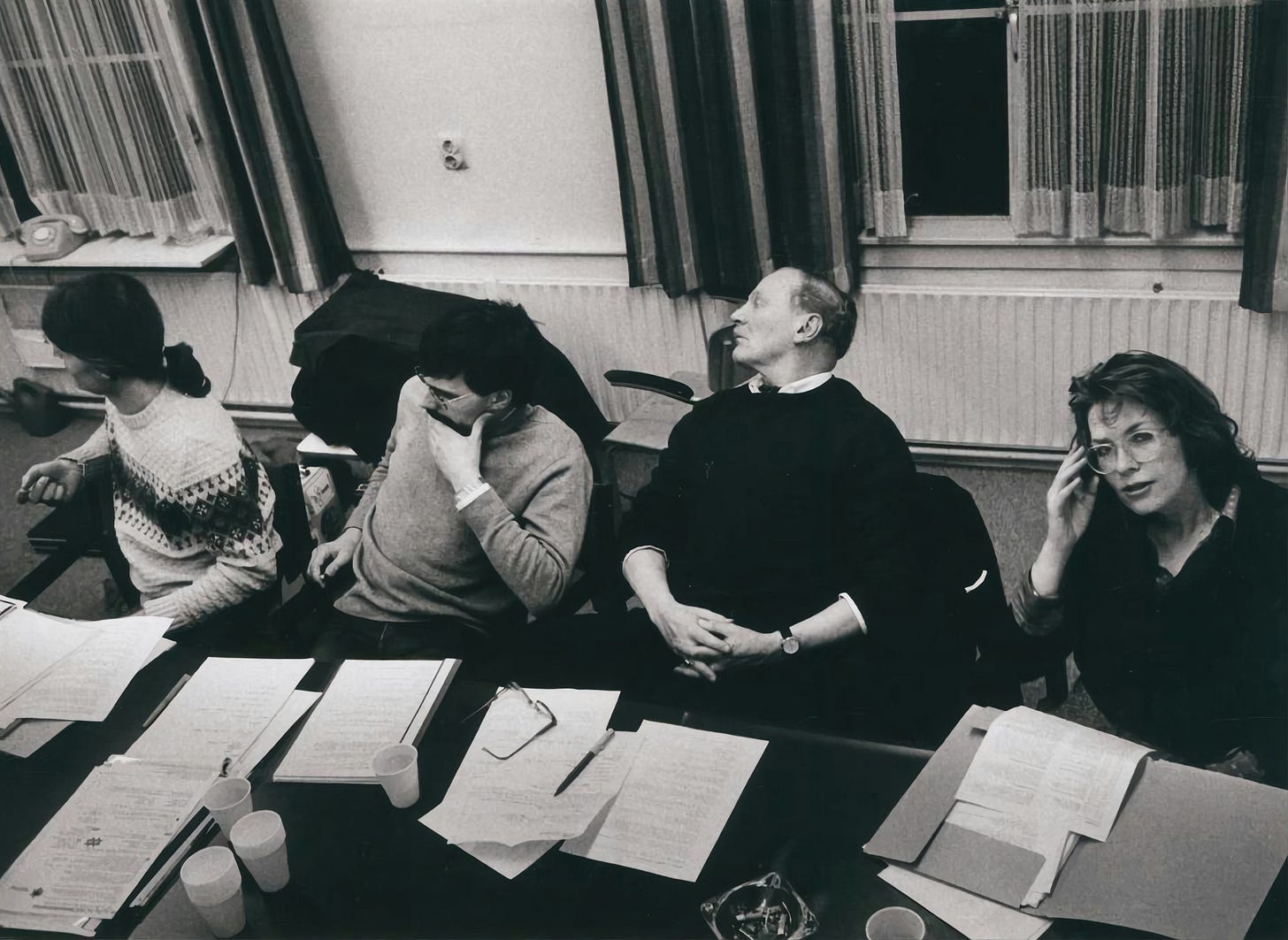 People sitting around a paper-strewn conference table