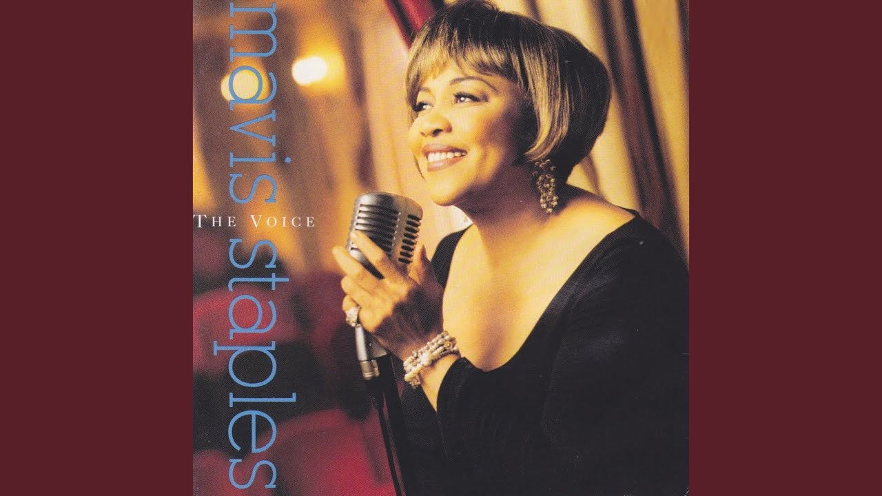 album cover for Mavis Staples' 1993 album 'The Voice,' featuring text on the left side and Staples in a black stress holding an old-school microphone