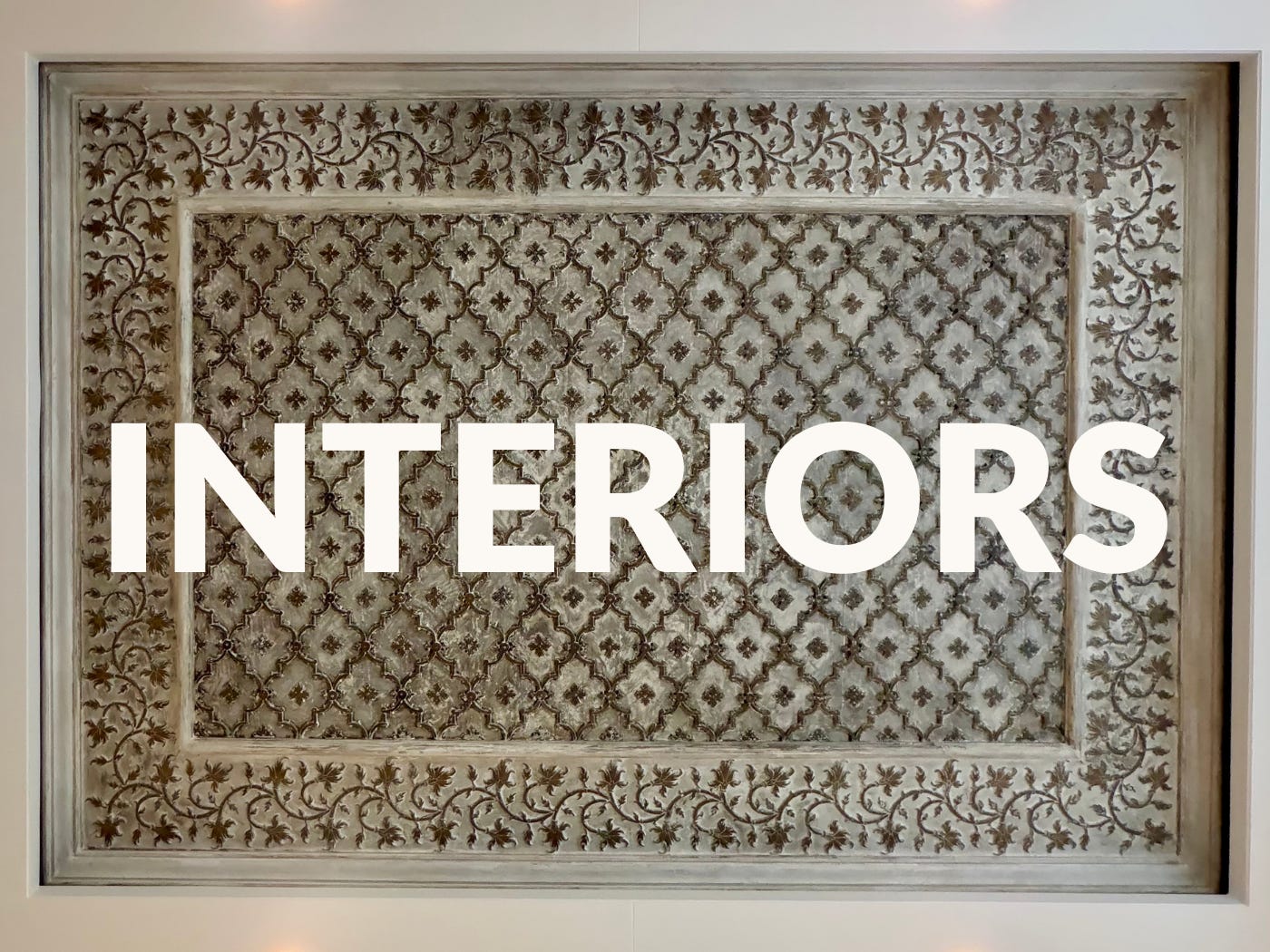 Close-up of a patterned decorative panel with the word “INTERIORS” overlaid.
