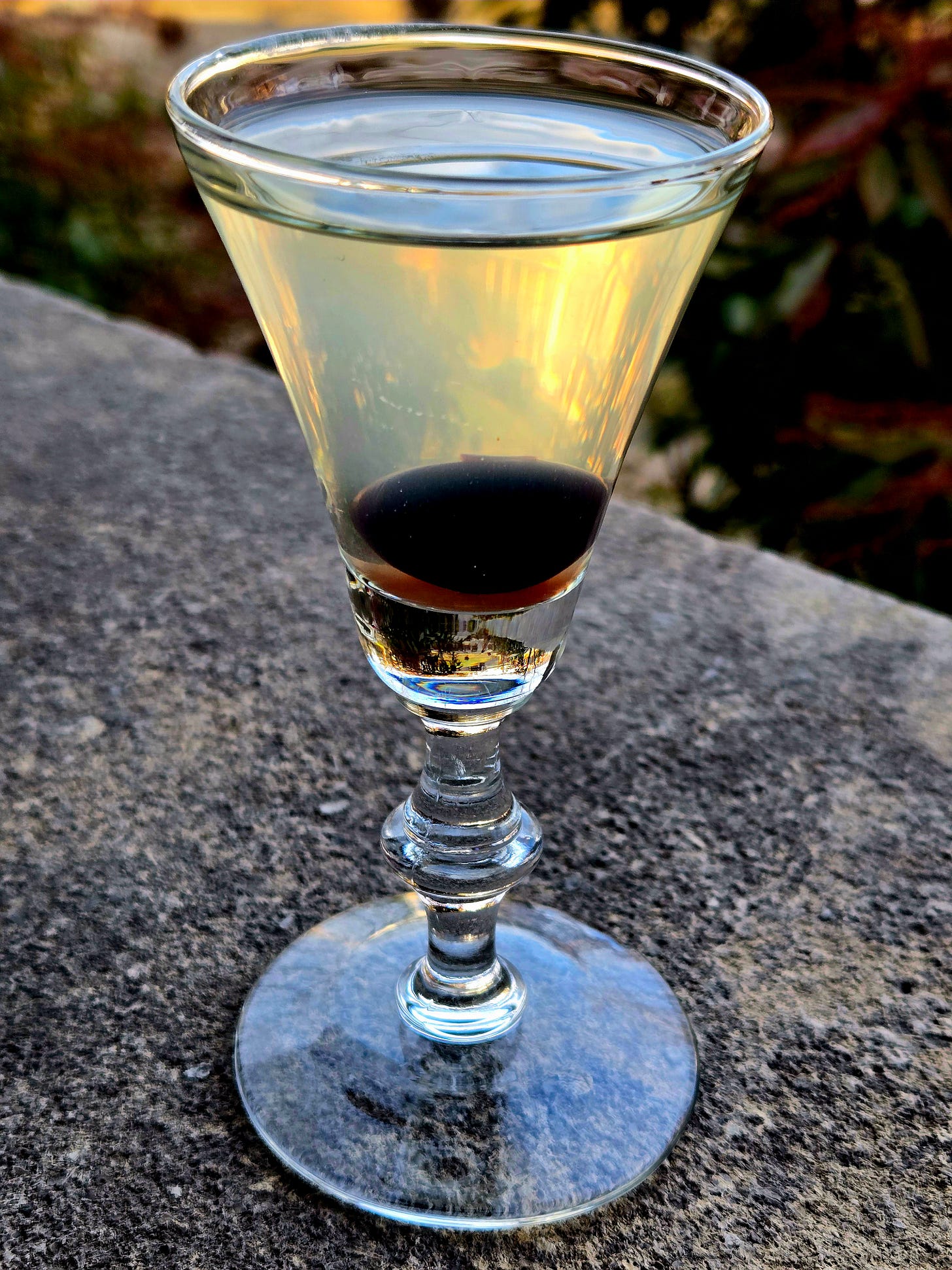 The Last Word cocktail in a cordial glass with cherry garnish atop a stone wall. The Last Word cocktail in a cordial glass with cherry garnish atop a stone wall.