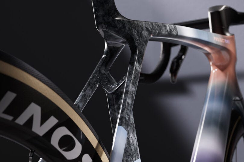 Close-up of a bicycle's rear triangle and seat post, featuring a sleek carbon fiber frame and aerodynamic design