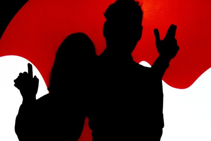 a man and a woman standing in front of a red sun