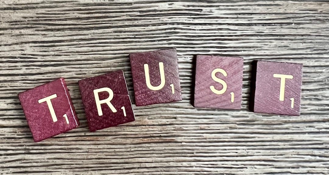trust spelled with wooden letter blocks on a table trust spelled with wooden letter blocks on a table