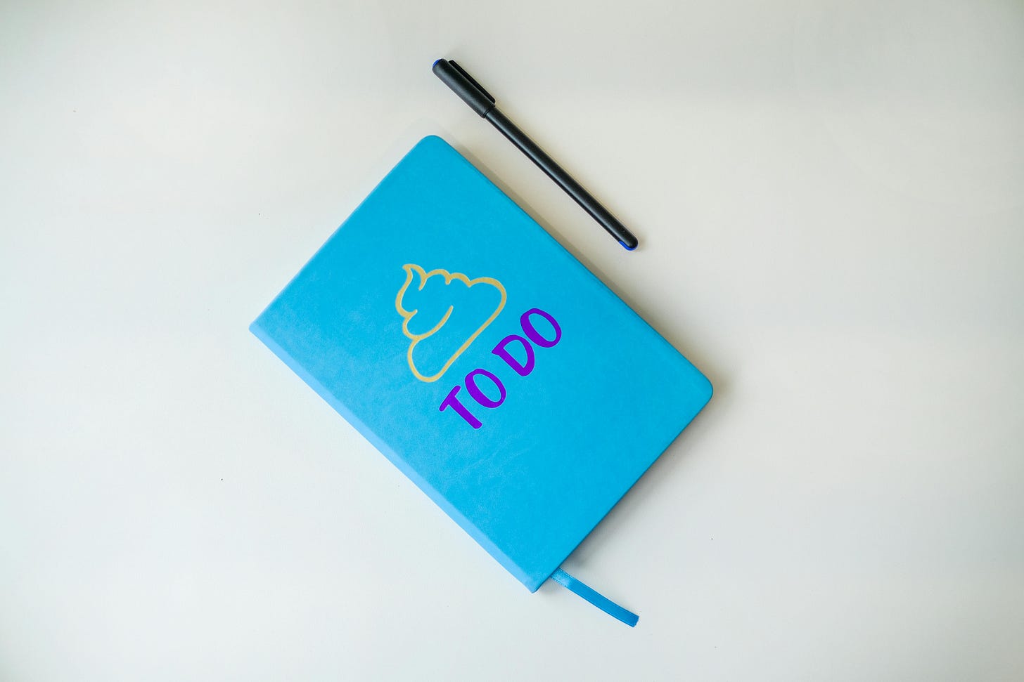 Photo of a blue planner with pen Photo of a blue planner with pen