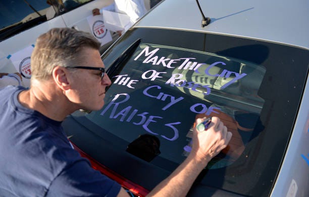 Vincent De Stefano paints on his rear window along with other members of Pasadenans Organizing for Progress and the National Day Laborer Organizing...