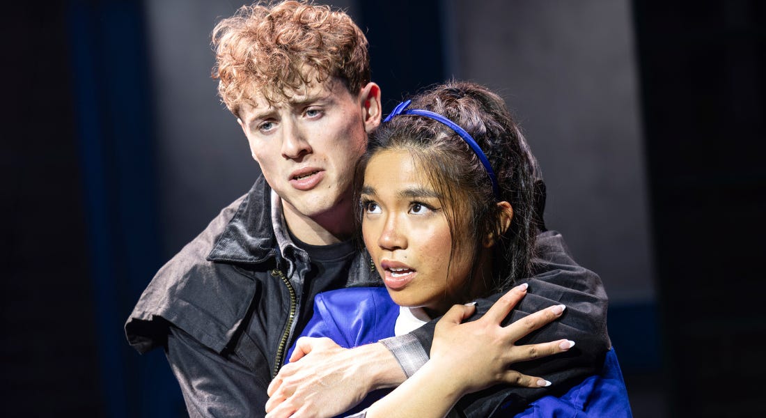 A close up of a man and a woman on stage - the man with a black jacket and the woman with a blue uniform A close up of a man and a woman on stage - the man with a black jacket and the woman with a blue uniform