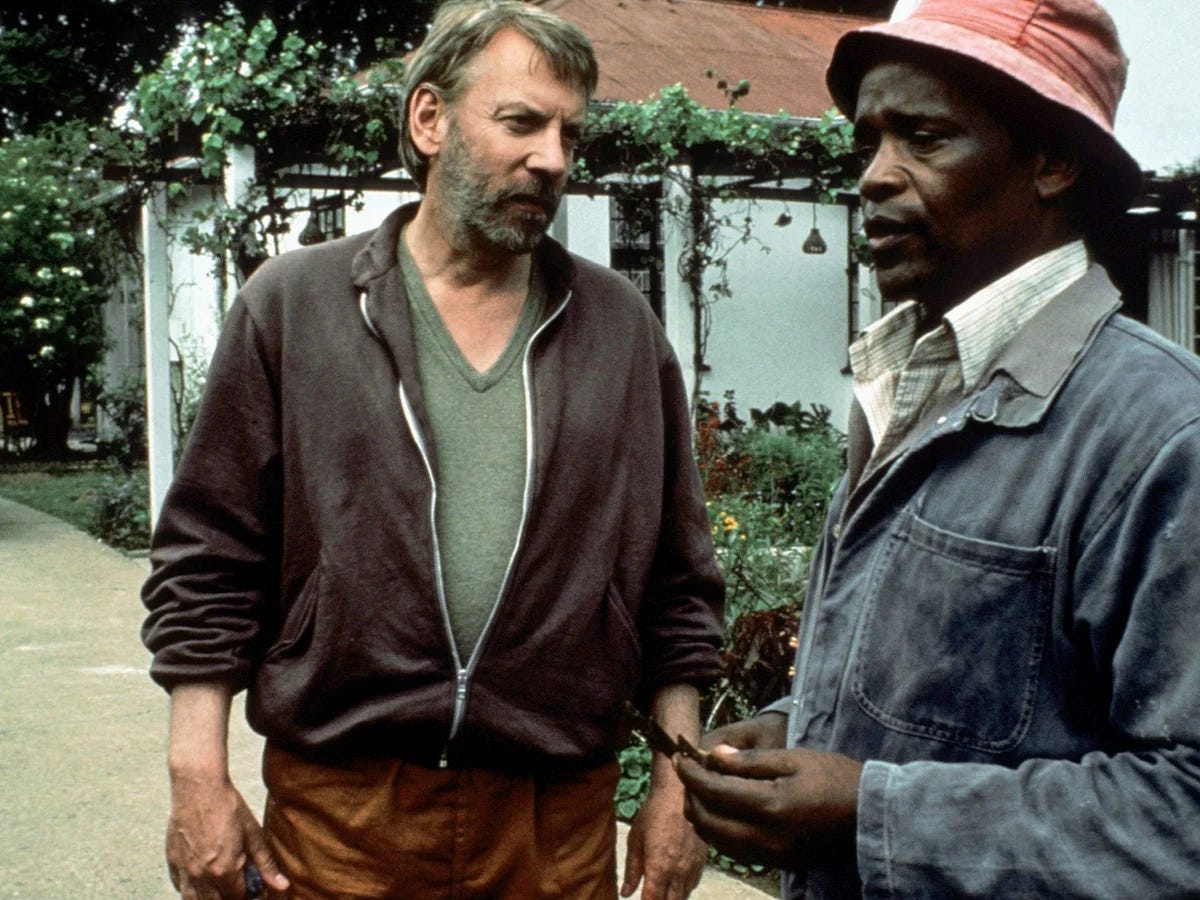 shlubby Donald Sutherland talks earnestly to Winston Ntshona in outdoor scene in Dry White Season shlubby Donald Sutherland talks earnestly to Winston Ntshona in outdoor scene in Dry White Season