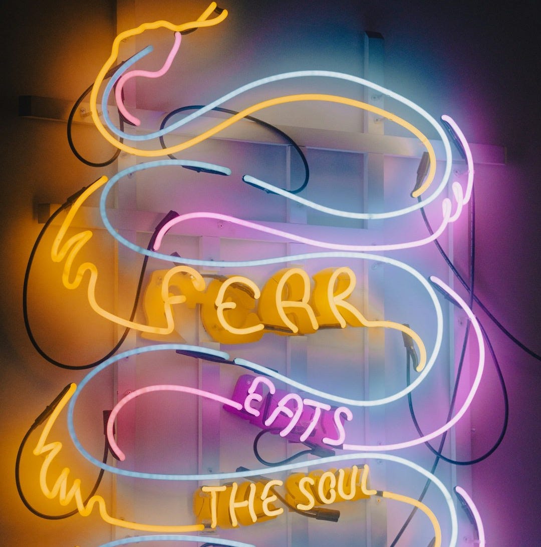 a neon sign that says fear eats the soul