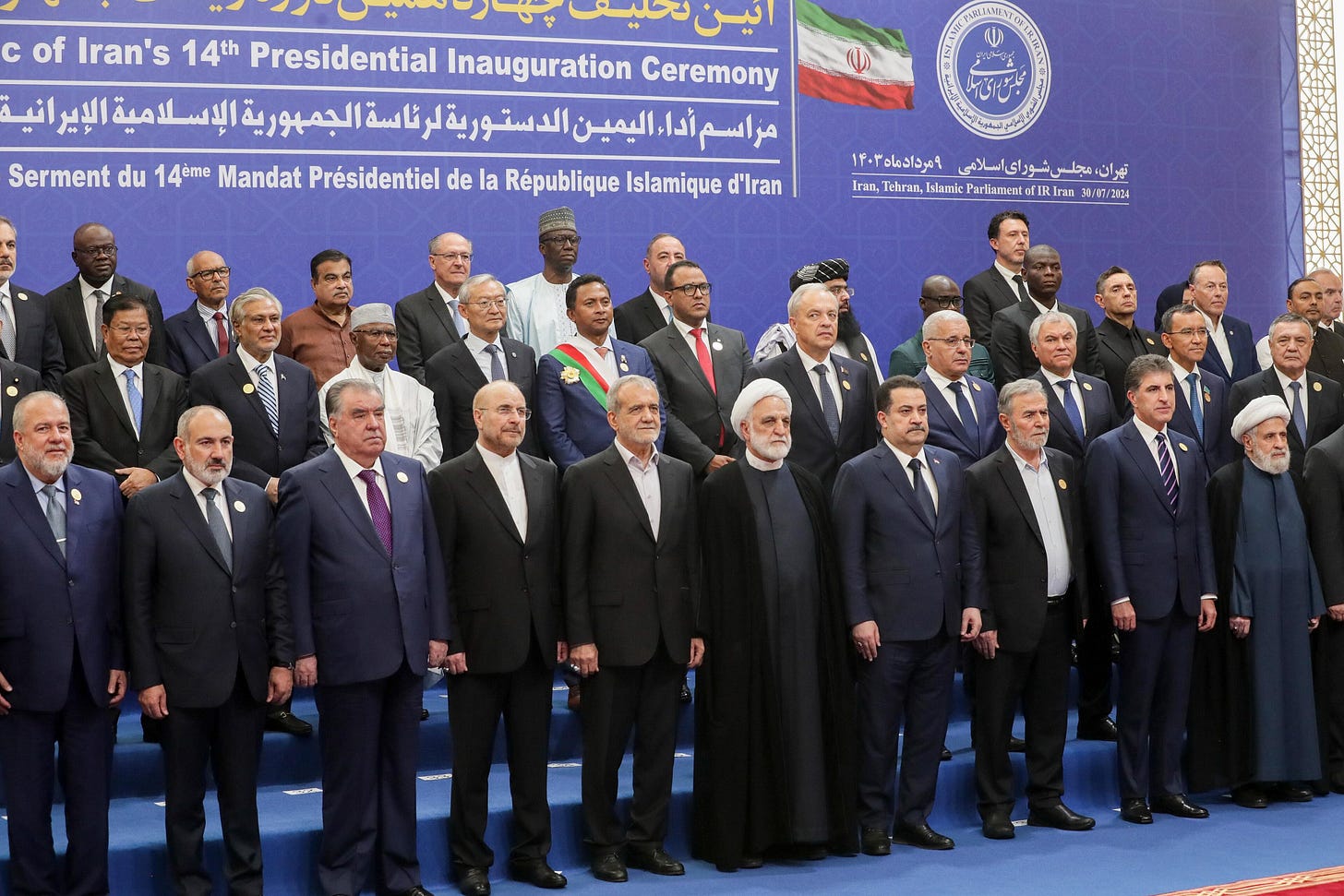 Dozens of foreign dignitaries in suits stand in rows for an official photo in front of a blue banner reading Islamic Republic of Iran's 14th Presidential Inauguration Ceremony; Brazil's Geraldo Alckmin is in the back row and a white-turbaned Hezbollah cleric stands at the right of the front row. Dozens of foreign dignitaries in suits stand in rows for an official photo in front of a blue banner reading Islamic Republic of Iran's 14th Presidential Inauguration Ceremony; Brazil's Geraldo Alckmin is in the back row and a white-turbaned Hezbollah cleric stands at the right of the front row.