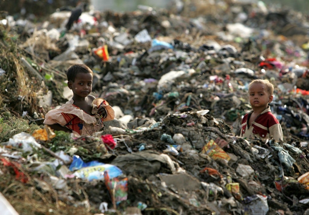 Children of rag-pickers stand amid a heap of garbage on the outskirts of New Delhi in 2006. Photo by Kamal Kishore/Reuters  