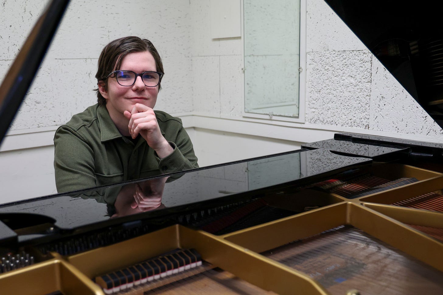 Patrick Morehead sits at a Kawai baby grand piano in the Music building’s practice room on Monday, April 7. When he is at home, he composes music on an Arturia Keylab 88 keyboard. (Erica Lee | Warrior Life)