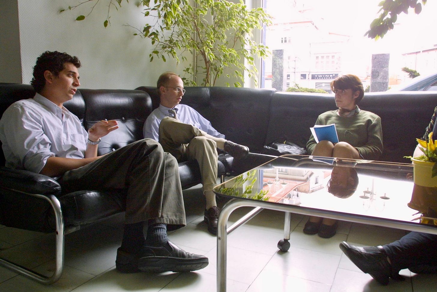Two men sitting at a table in what appears to be a meeting or interview setting in Poland, one taking notes while the other speaks, demonstrating collaborative journalism work. Two men sitting at a table in what appears to be a meeting or interview setting in Poland, one taking notes while the other speaks, demonstrating collaborative journalism work.