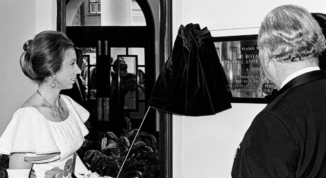 A black and white picture of Princess Anne - a woman in a white dress standing next to a man, looking at a plaque A black and white picture of Princess Anne - a woman in a white dress standing next to a man, looking at a plaque