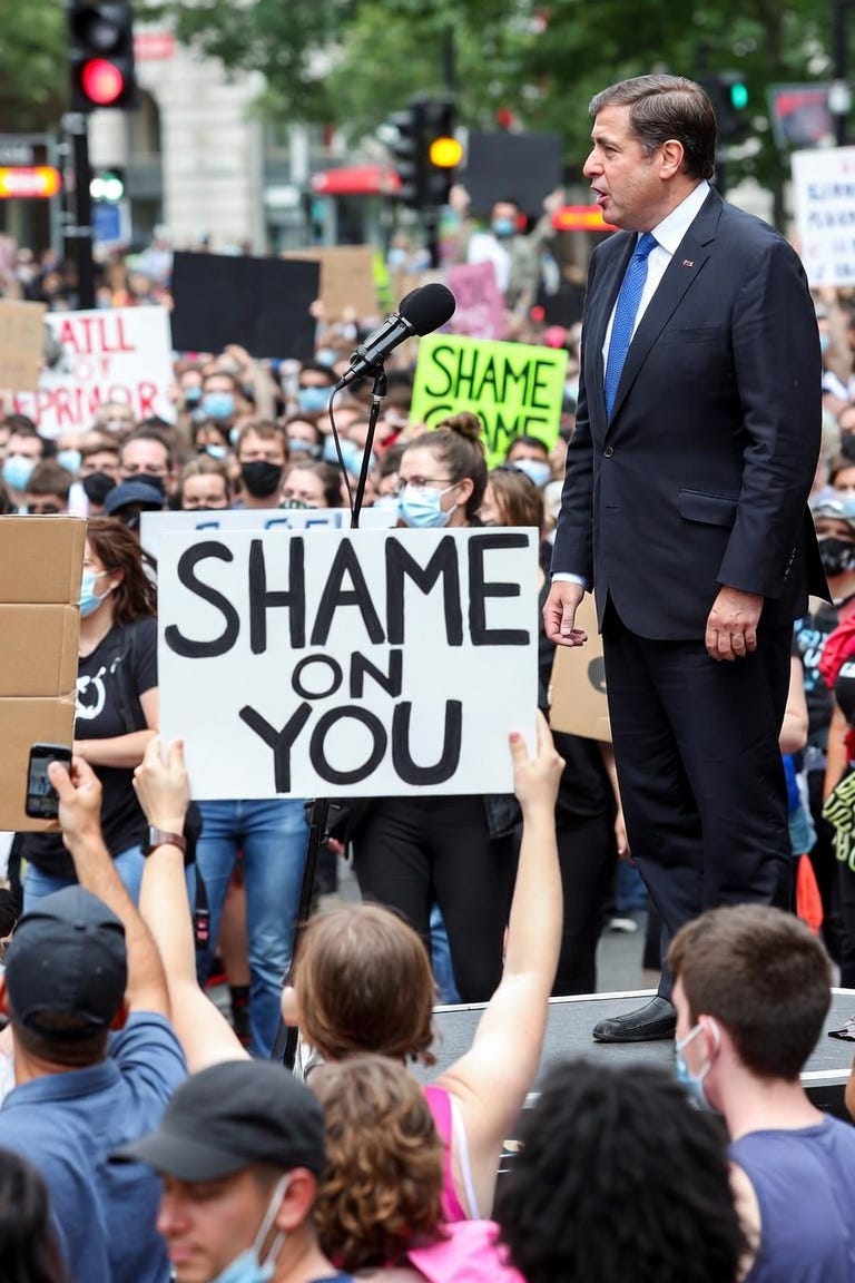 a mob of protestors insulting a politician a mob of protestors insulting a politician