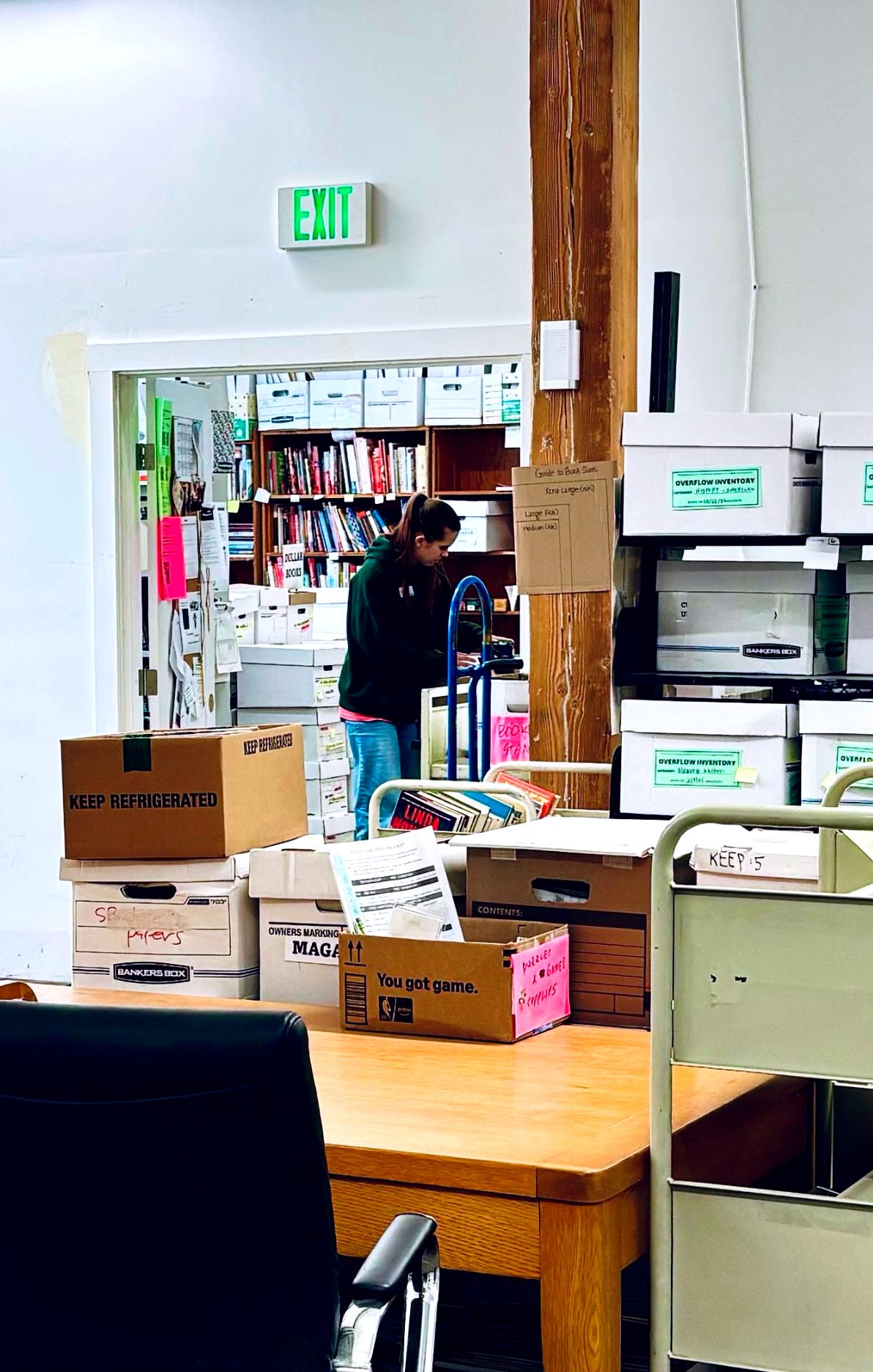 A volunteer processes donated books for resale at The Bookmark. (Image source: Oakland Report)