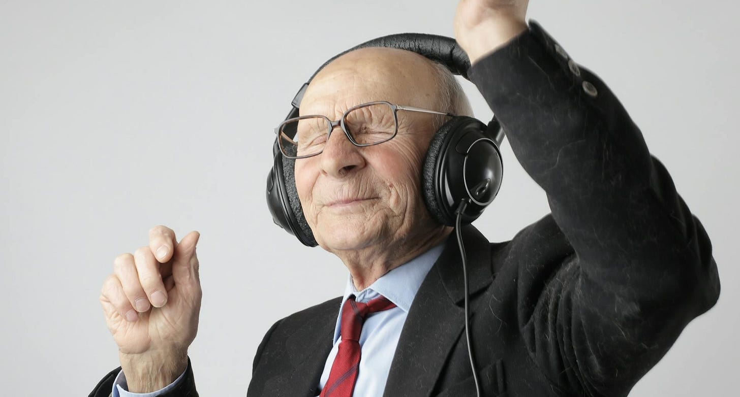 Old man dancing to music with headphones on