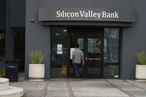 A man reading notices posted on the doors of a Silicon Valley Bank location.