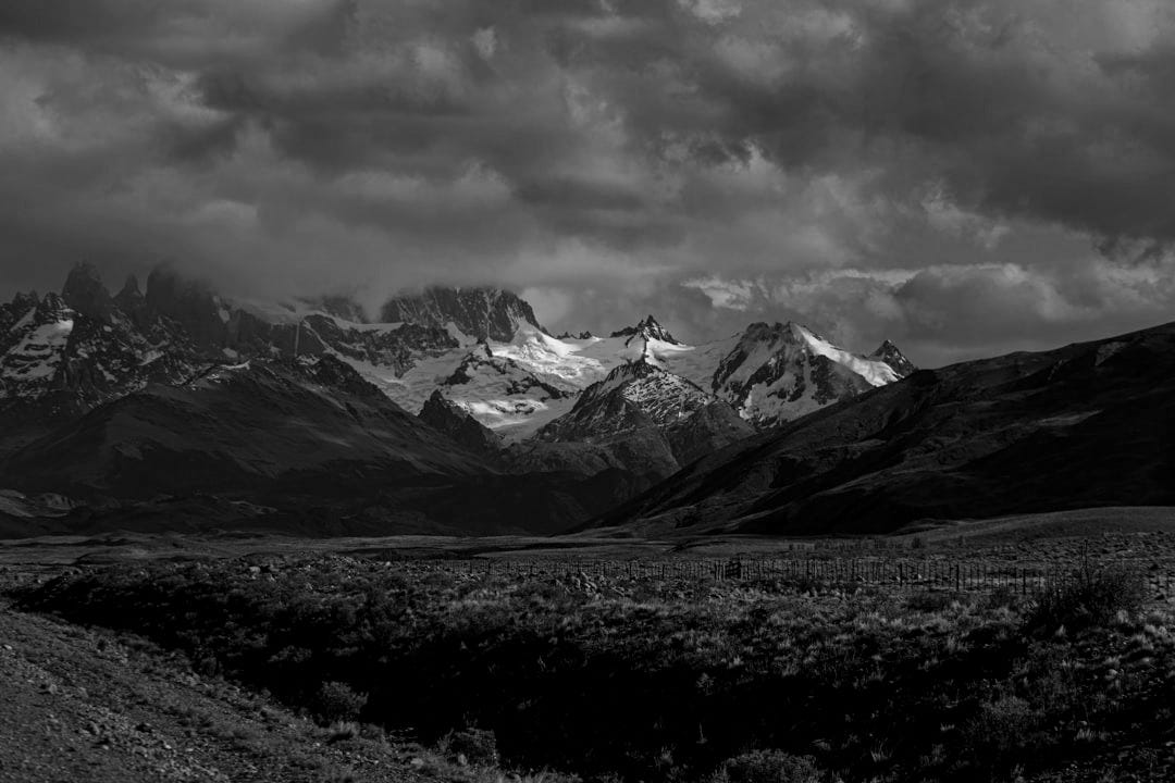 a mountain range with snow capped mountains in the distance