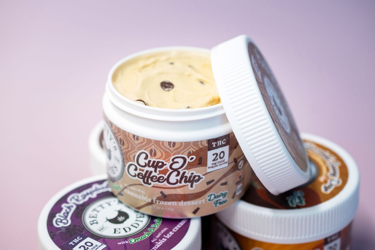 An open jar of Merimed's new frozen dessert, sitting on top of two unopened jars.