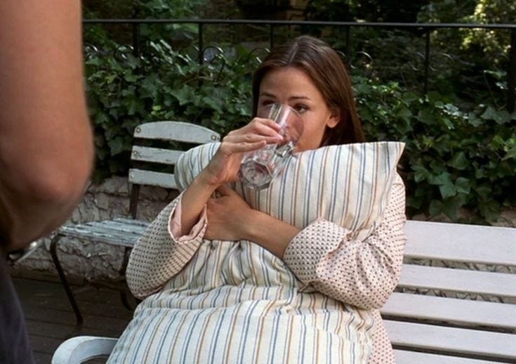 This may contain: a woman sitting on a bench drinking from a wine glass This may contain: a woman sitting on a bench drinking from a wine glass