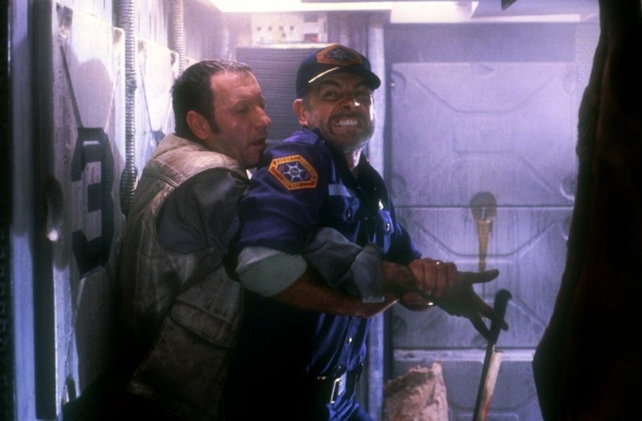 Connery in a cap and marshall outfit fighting some guy who has grabbed him from behind in a space closet labelled number 3 Connery in a cap and marshall outfit fighting some guy who has grabbed him from behind in a space closet labelled number 3