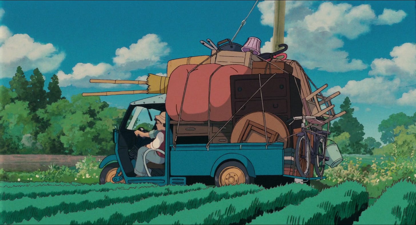 An actual artistically rendered frame from My Neighbor Totoro, created by humans. A man drives a little truck through a farm field. The truck is piled high with things for moving into a new home.