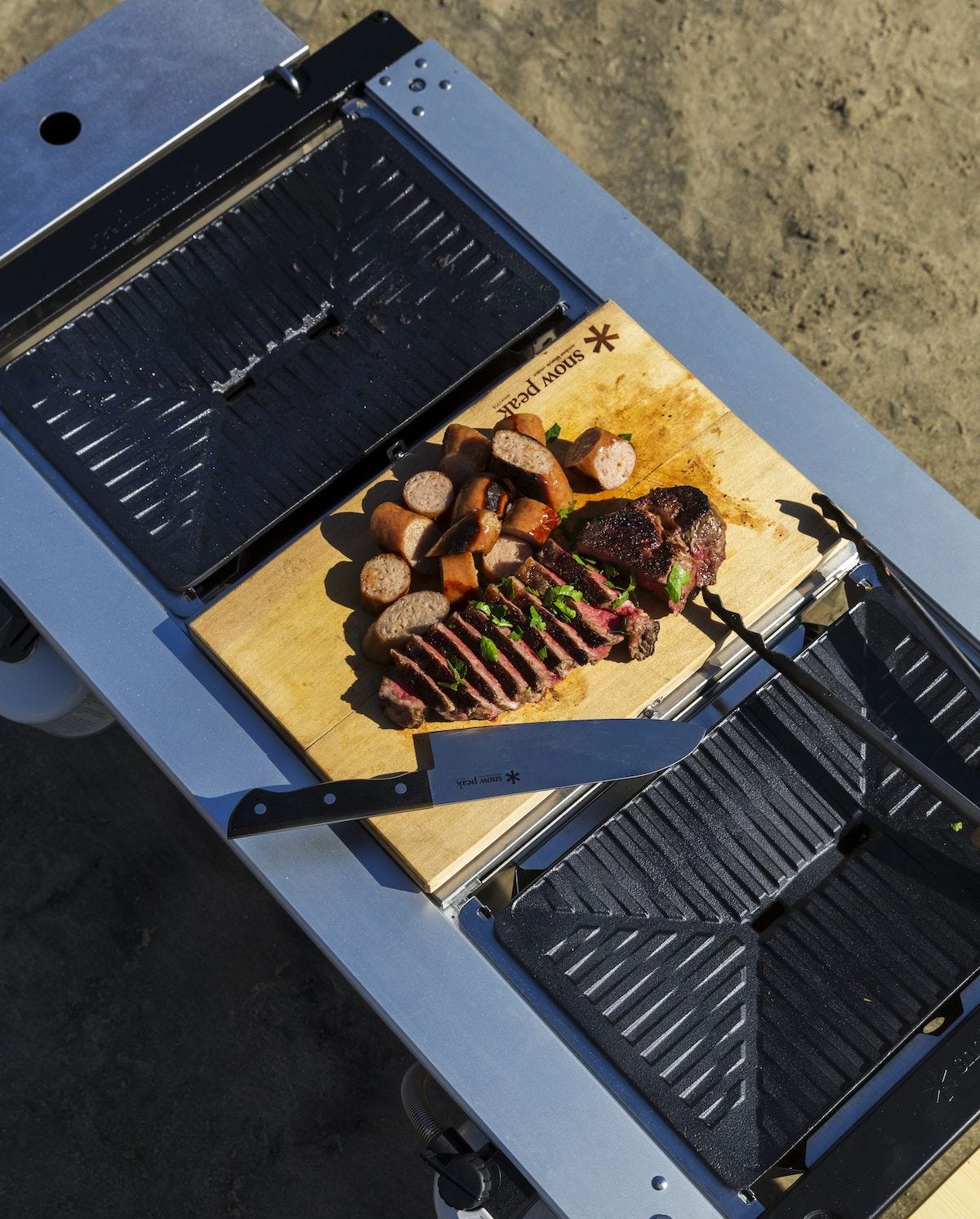 Prepared meat served on a Snow Peak cutting board during a camping meal Prepared meat served on a Snow Peak cutting board during a camping meal