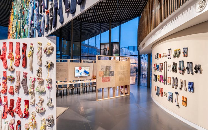 Photos of the NOW Gallery x Celia Pym exhibition Socks: The Art of Care and Repair showing a display of 488 pairs of mended socks [Credit: NOW Gallery].