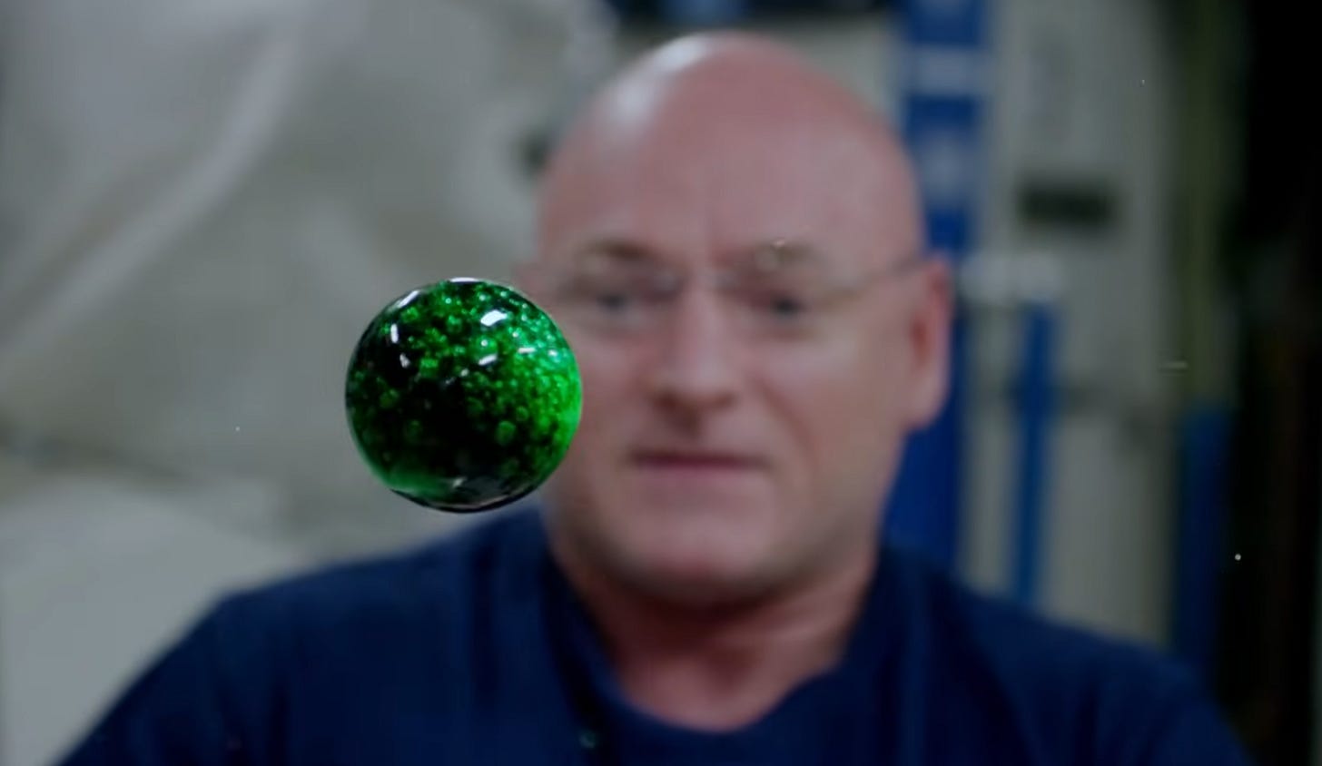 Astronaut on IIS with floating ball of colored water Astronaut on IIS with floating ball of colored water