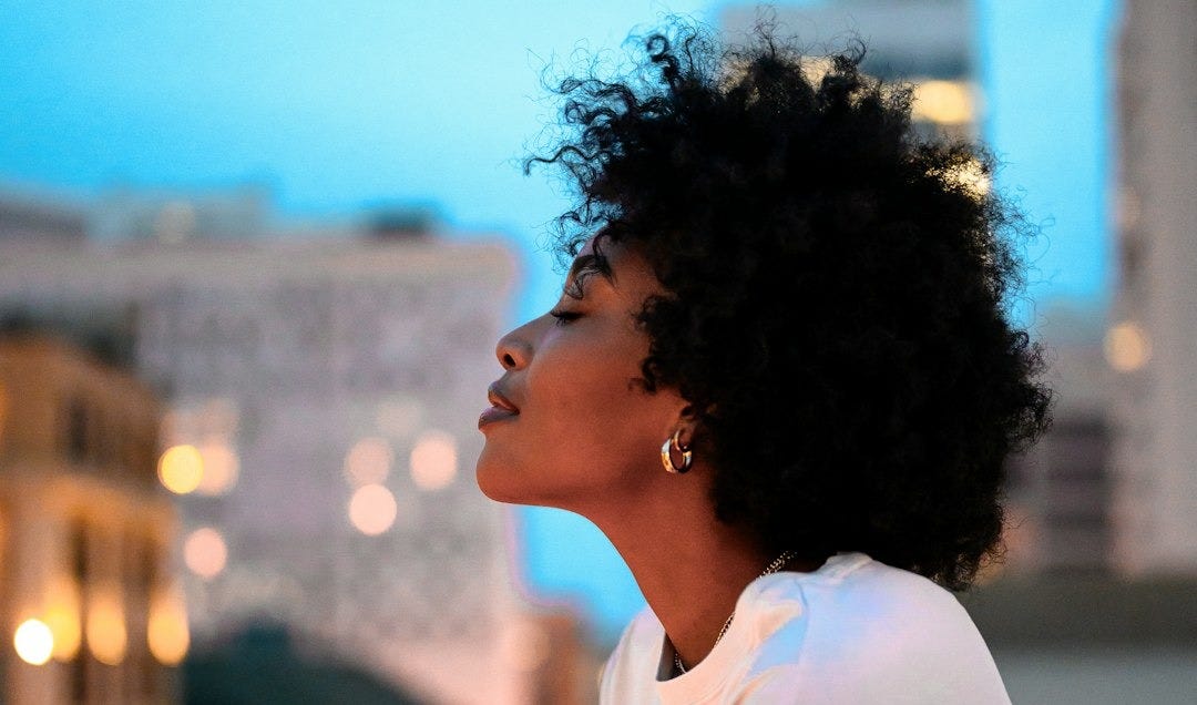 woman in white collared shirt looking at the city during night time