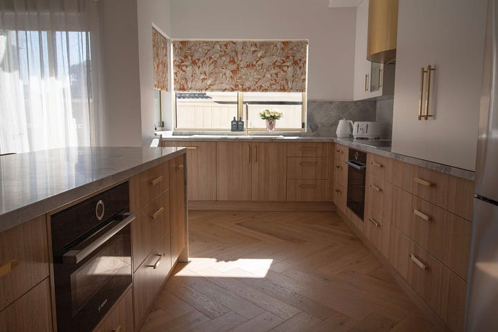 luxury resort-style kitchen in wood grain and super white quartzite designed by Plush Design Interiors and Penelope Herbert