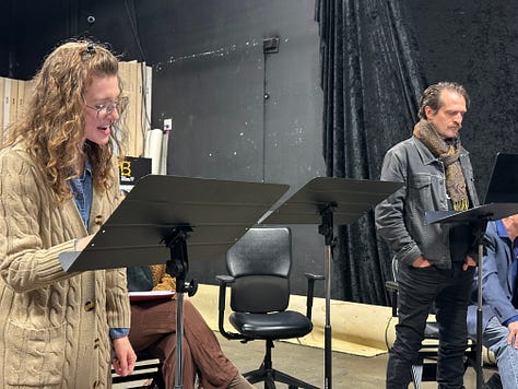 Actors reading a play in a theater.
