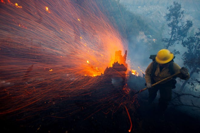 The wind whips embers while a firefighter battles the fire in the Angeles National Forest near Mt. Wilson as the wildfires burn in the Los Angeles area, during the Eaton Fire in Altadena, California, U.S. January 9, 2025.