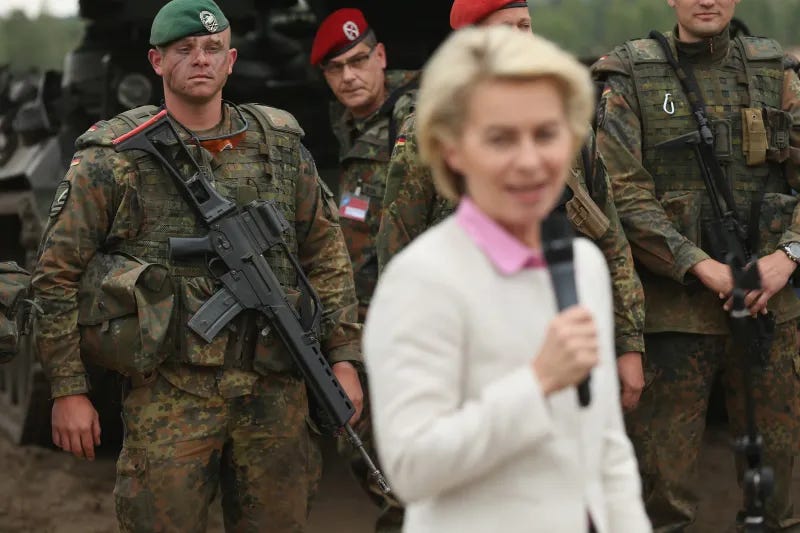 German troops, one of whom (left) is carrying a Heckler and Koch G36 rifle, look on as German Defense Minister Ursula von der Leyen speaks to the media while attending the NATO Noble Jump military exercises in Zagan, Poland.