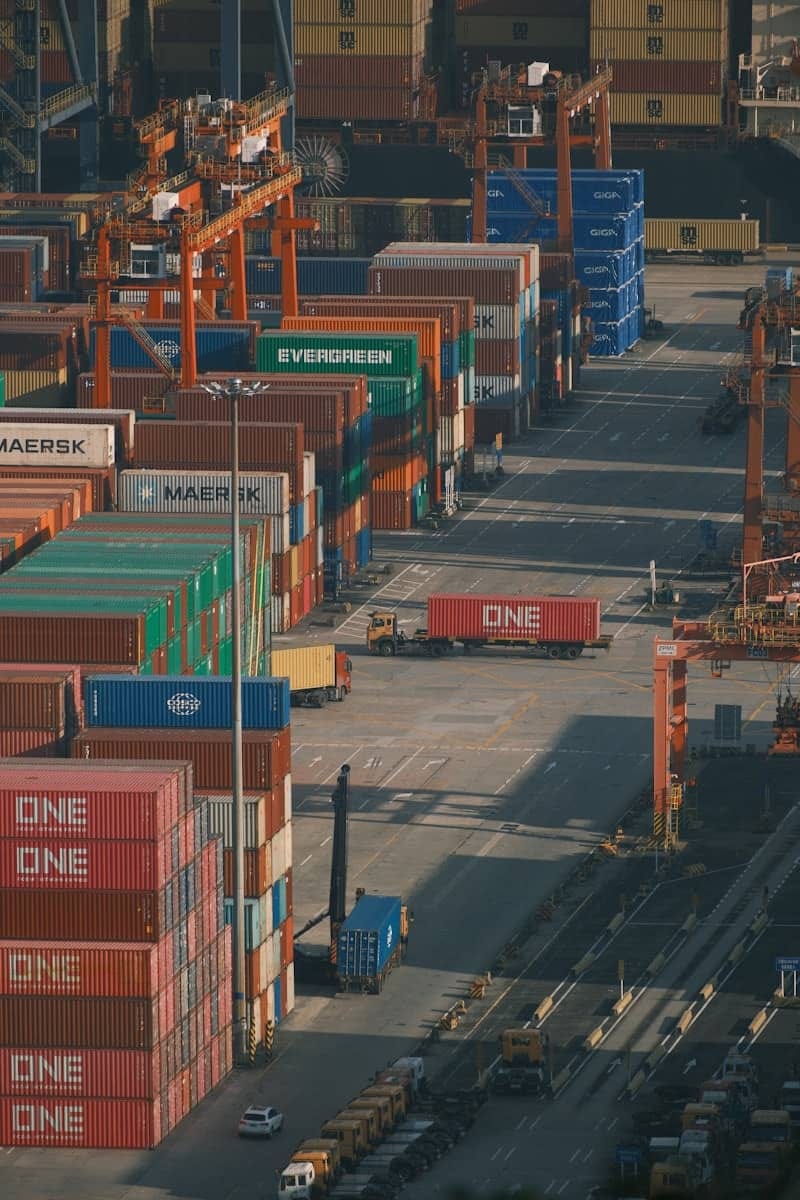 Shipping containers stacked high at a busy port.