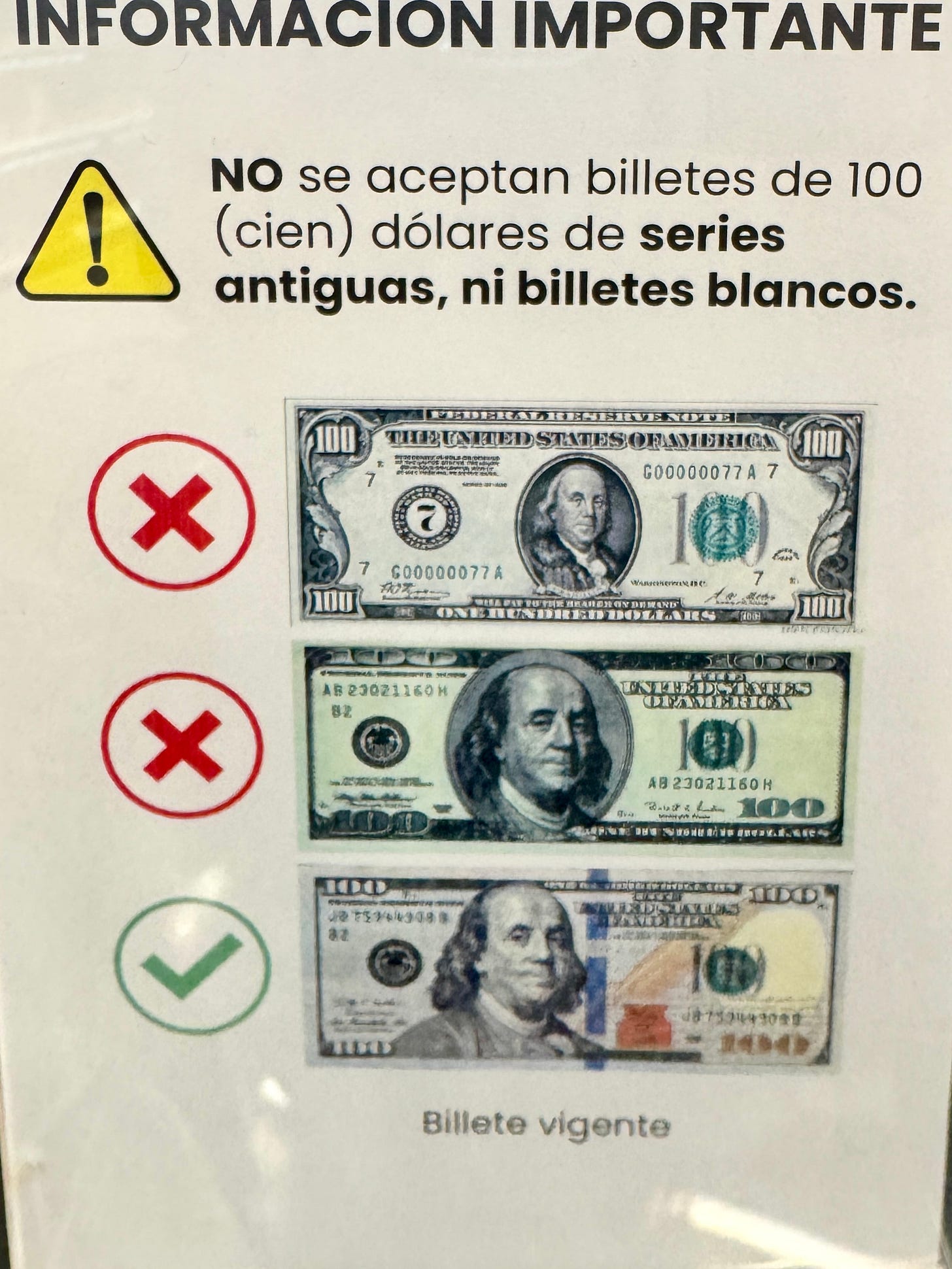 Aviso en una tienda sobre qué billetes de 100 USD se aceptan y cuáles no. 