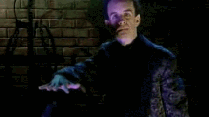 person on a dark tv screen seeming to summon another person. really they are kids in the hall comedians pretending to be evil tv hosts. person on a dark tv screen seeming to summon another person. really they are kids in the hall comedians pretending to be evil tv hosts.