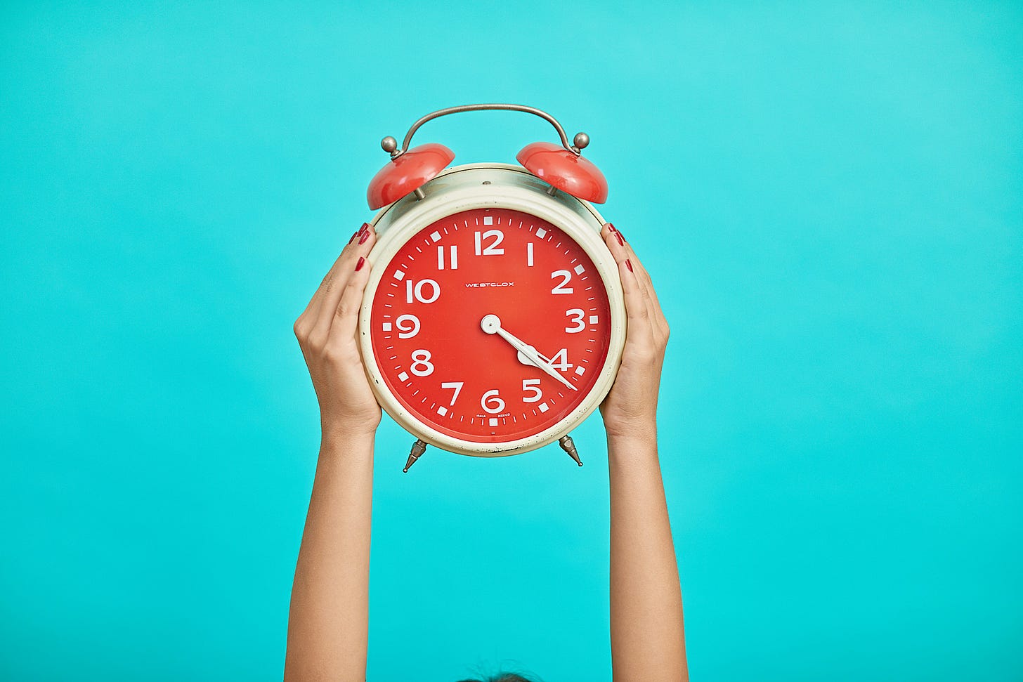 image of hands holding an alarm clock