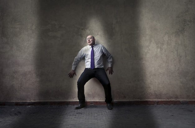Scared businessman on the wall | Premium Photo