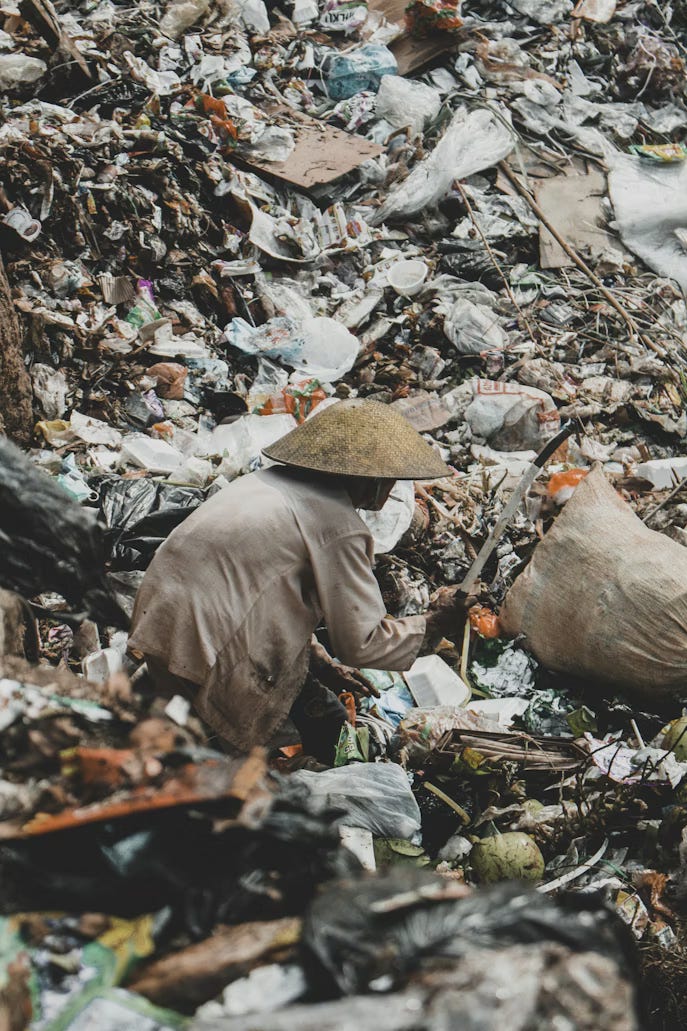 A scavenger collects plastic waste at a landfill in Indonesia