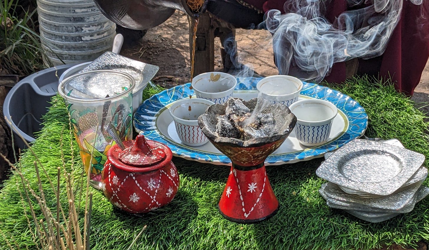 Coffee is being poured into a lovely coffee set of cups, saucers, and silver trays. There is incense burning in a red pot. Coffee is being poured into a lovely coffee set of cups, saucers, and silver trays. There is incense burning in a red pot.
