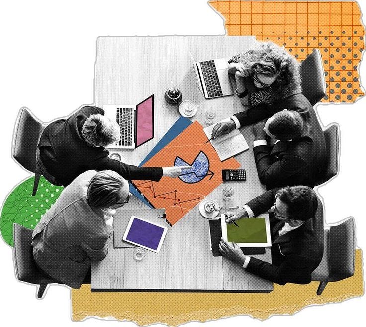 This may contain: four people sitting at a table with laptops and papers