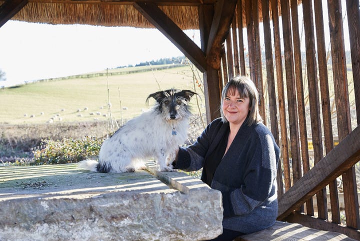 Photos of Jo Scott and her dog Thomasina with her dog art in her studio from 2018