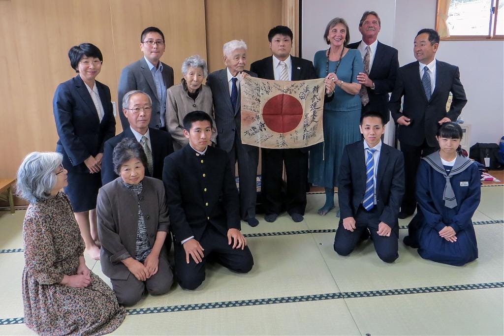 Japanese family members receive a returned yosegaki hinomaru flag from an American family, 2016 Japanese family members receive a returned yosegaki hinomaru flag from an American family, 2016