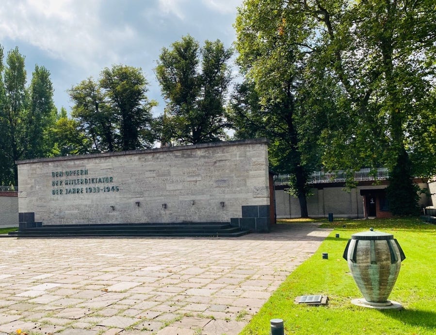 A stone wall with a sign in front of it

Description automatically generated